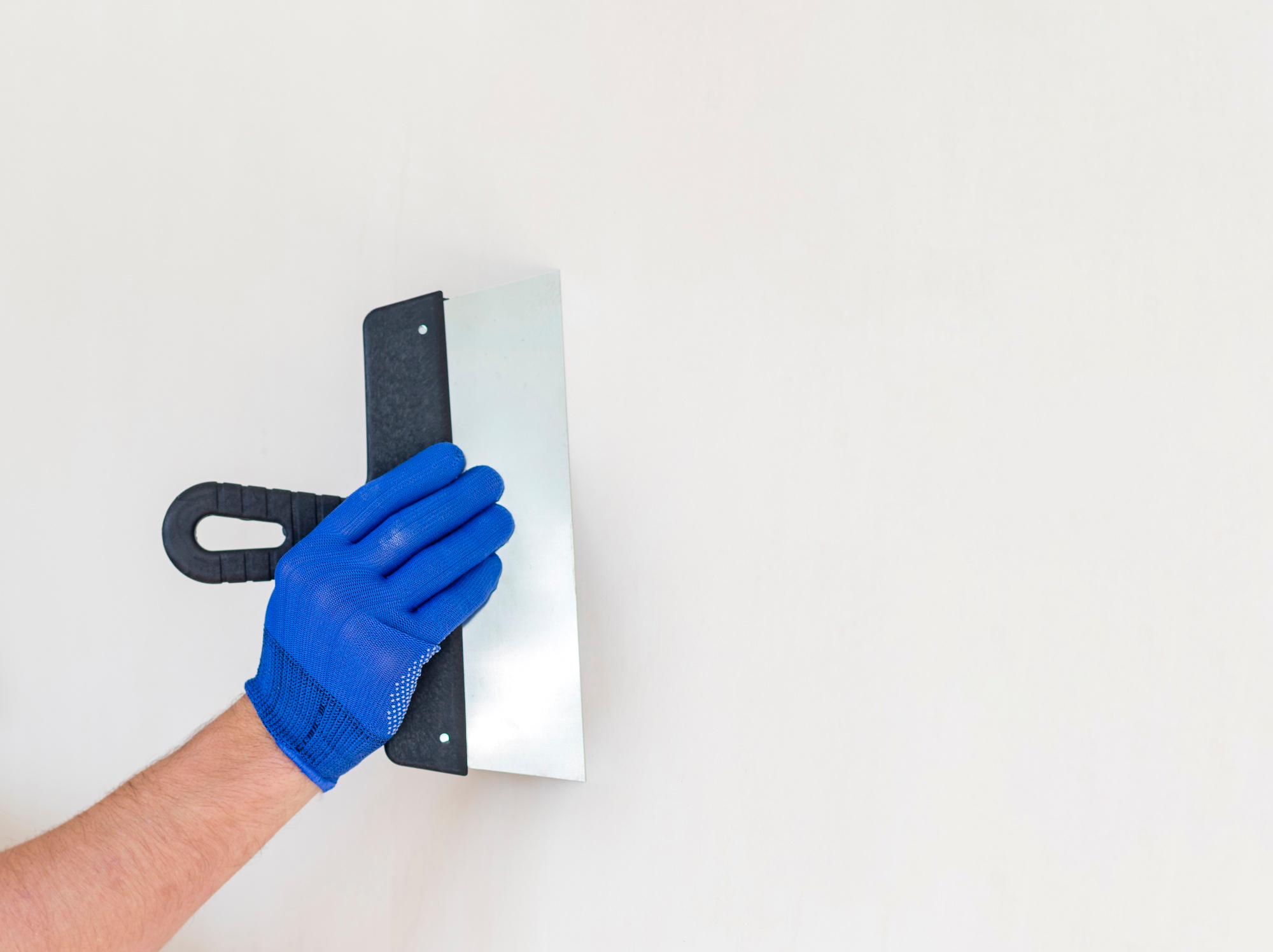 Werknemer schildert muren voor een perfecte afwerking door stukadoorsbedrijf in Groningen